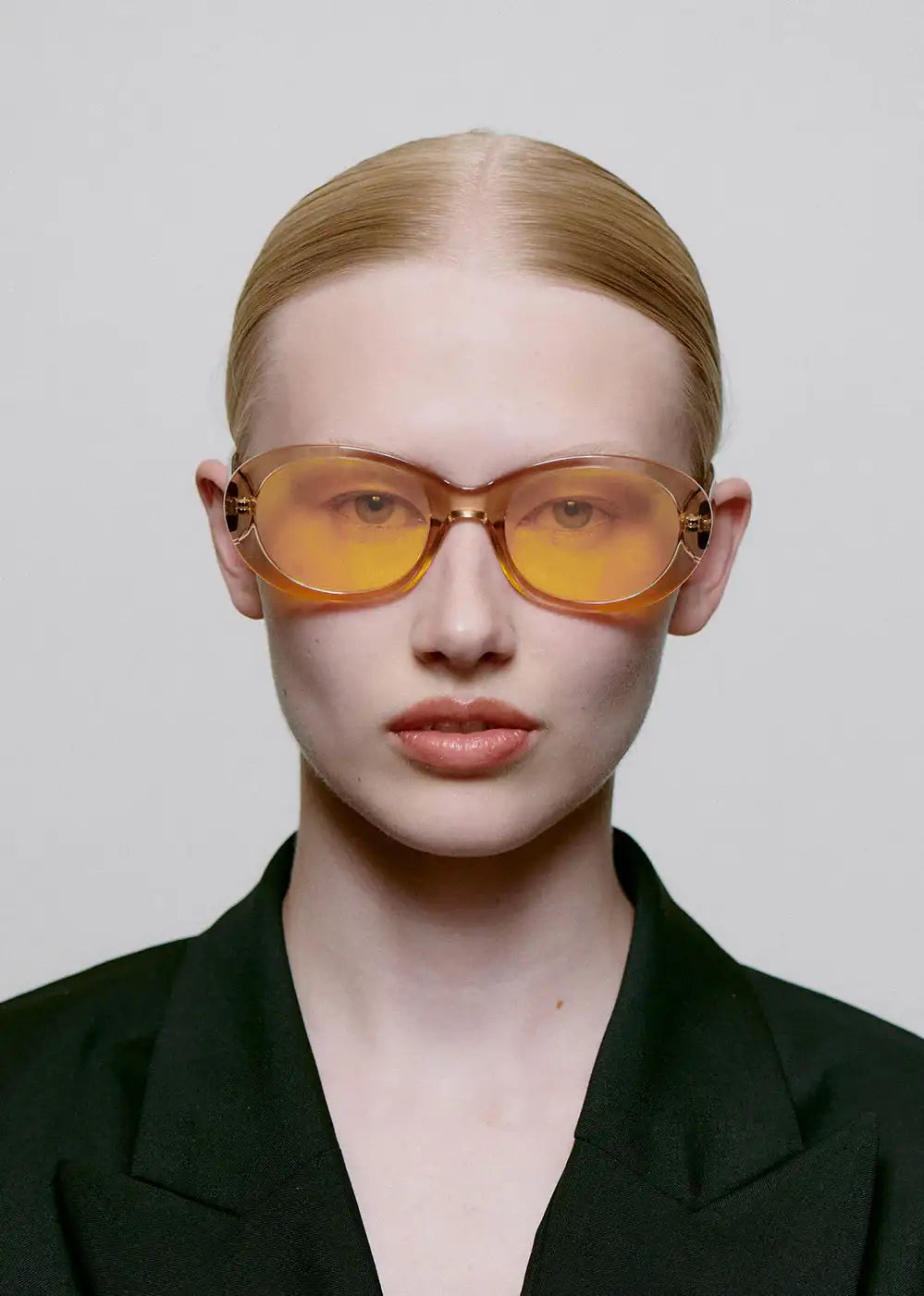 Woman wearing oversized champagne yellow sunglasses and black blazer, fashion eyewear