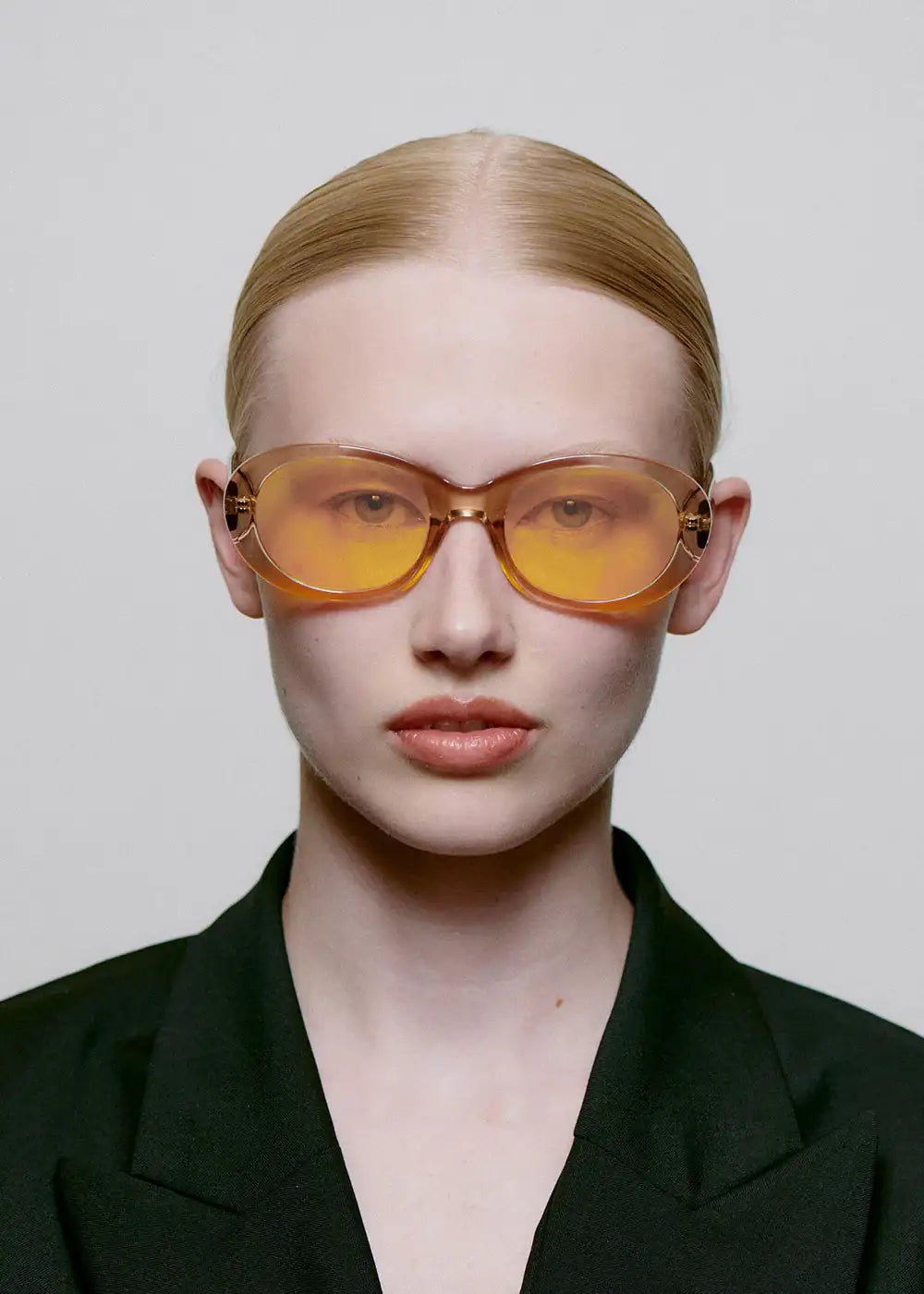 Woman wearing oversized champagne yellow sunglasses and black blazer, fashion eyewear
