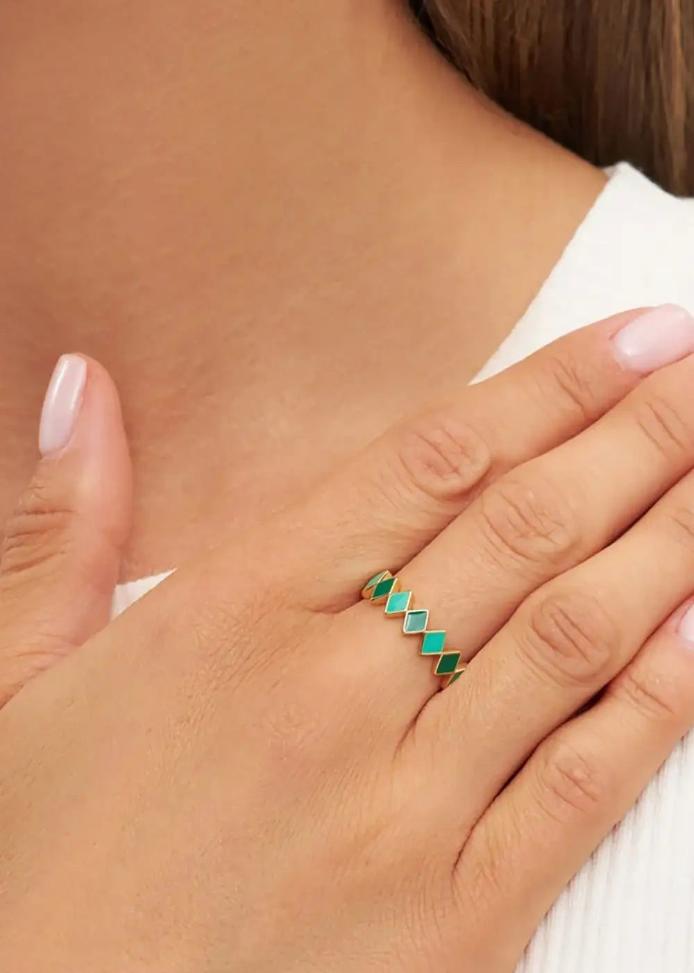 Gold plated ring with green diamond shapes on hand, modern geometric jewelry style