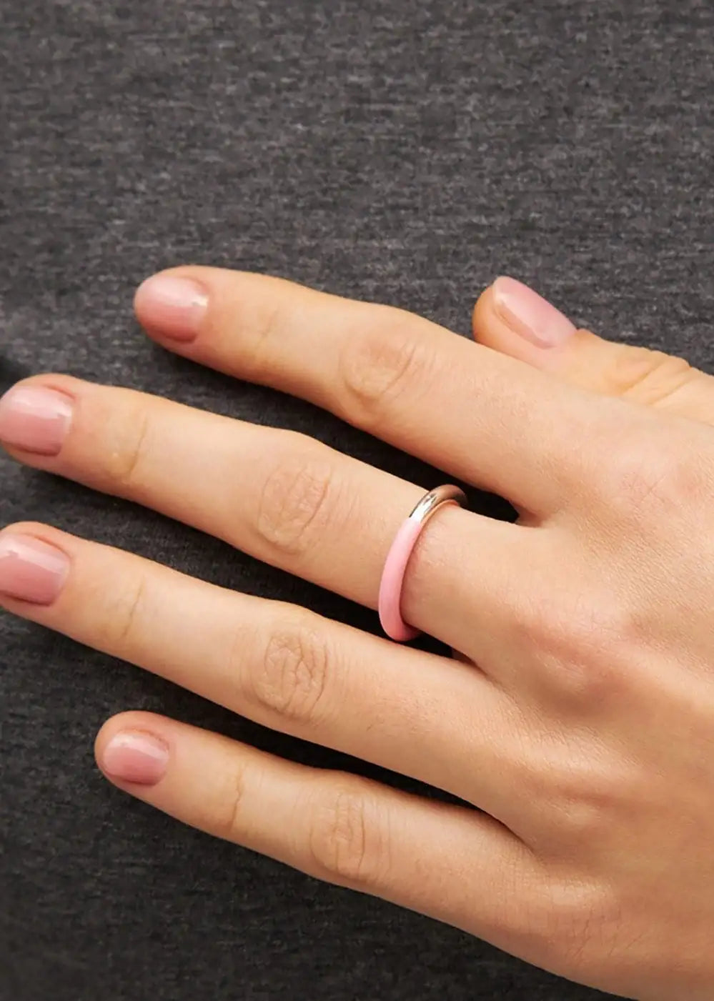 Silver and light pink double color ring on a hand with natural nails