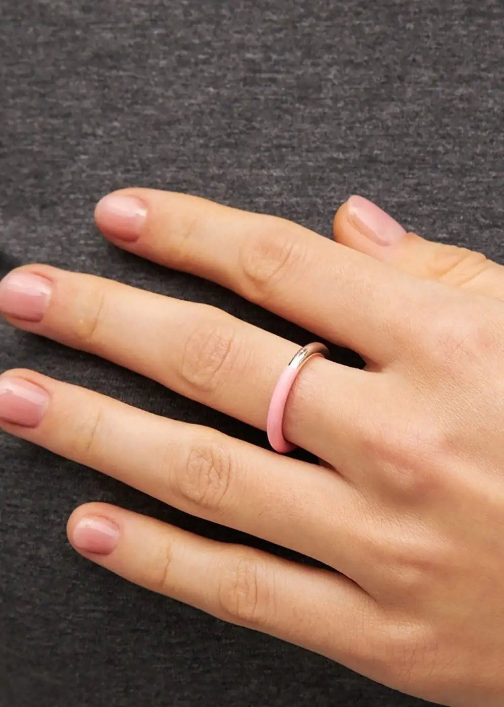 Silver and light pink double color ring on a hand with natural nails