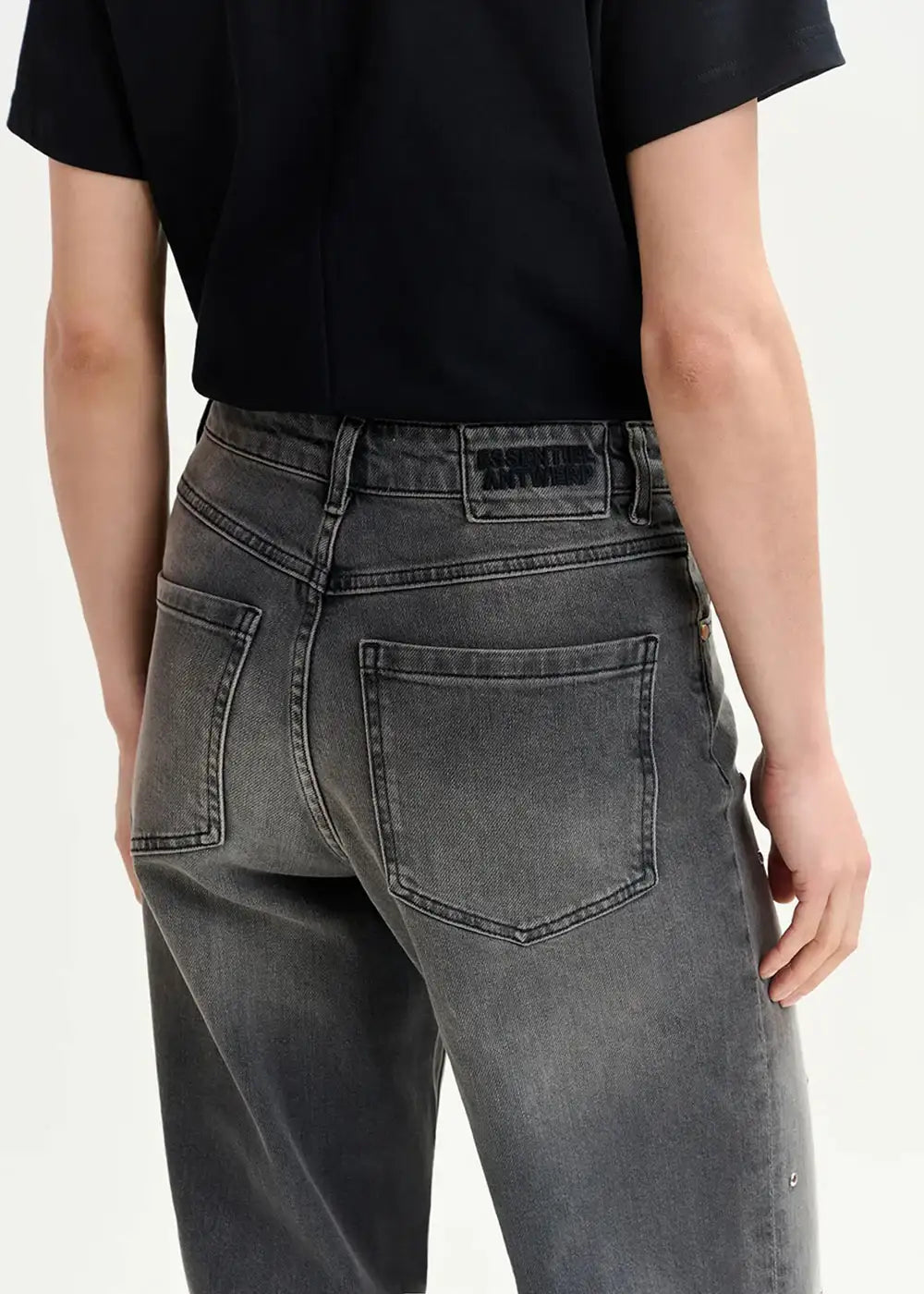 Back view of person wearing washed black straight-leg jeans and a black short-sleeve top