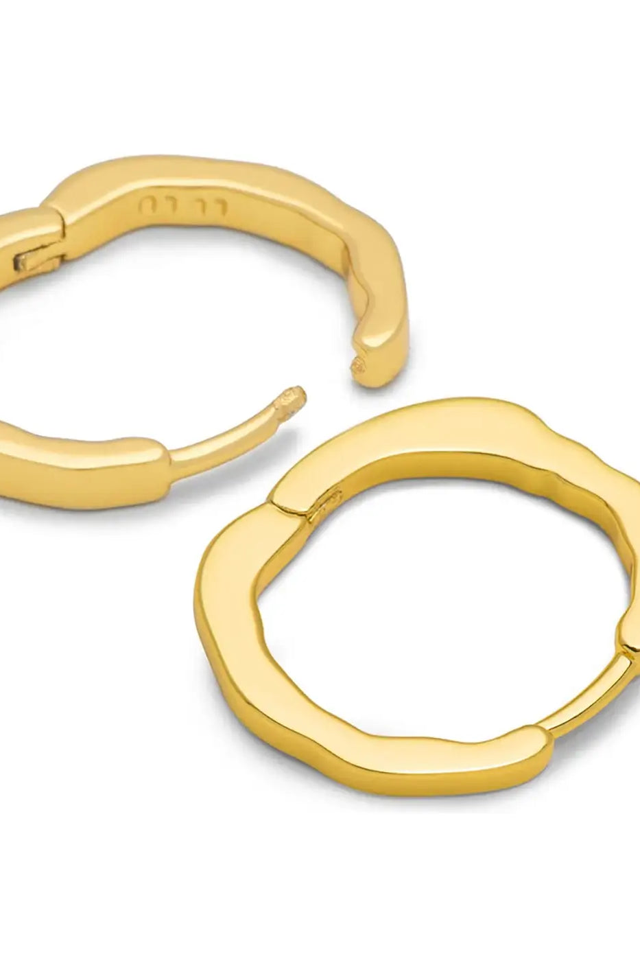Pair of organic-shaped gold plated hoop earrings on white background