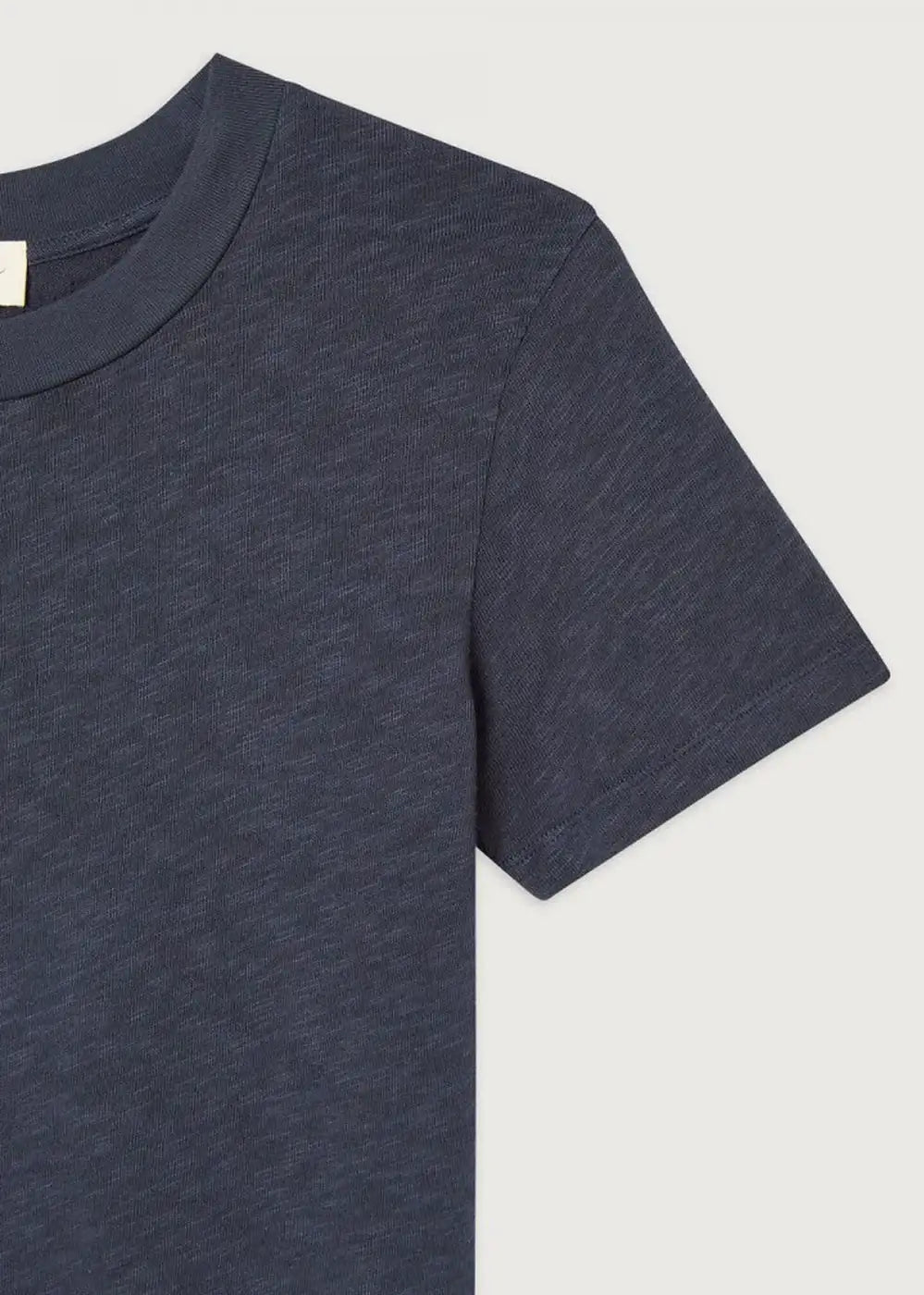 Close-up of a navy blue short sleeve cotton t-shirt against a light background