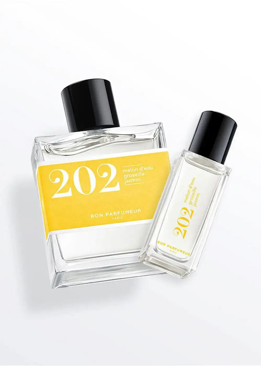 Two clear glass perfume bottles with yellow labels showing '202', black caps, on white background.
