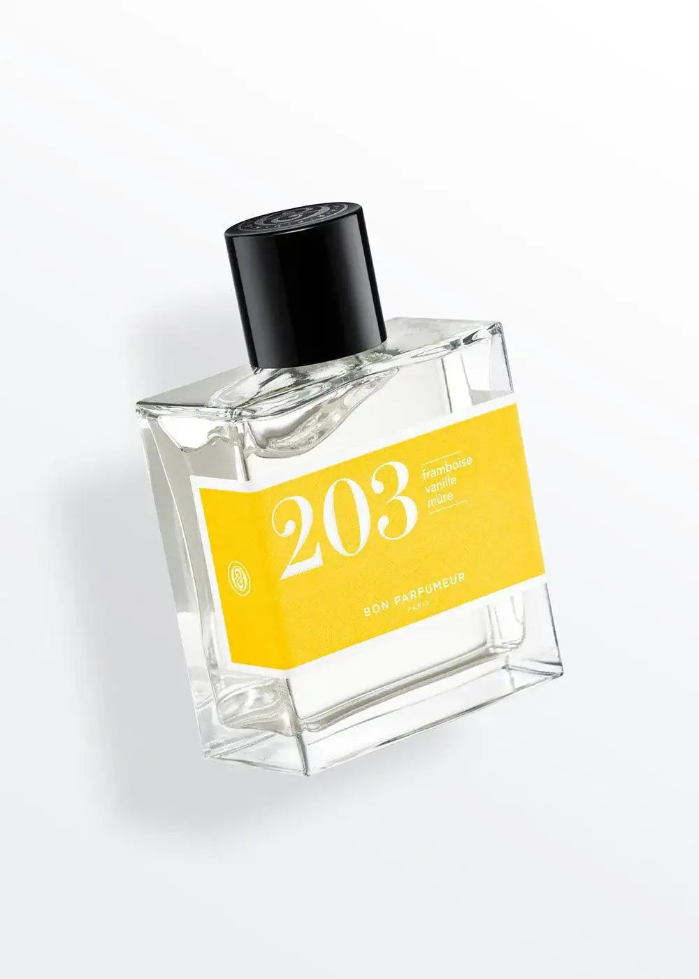 Clear glass perfume bottle labeled 203 with yellow label and black cap on white background