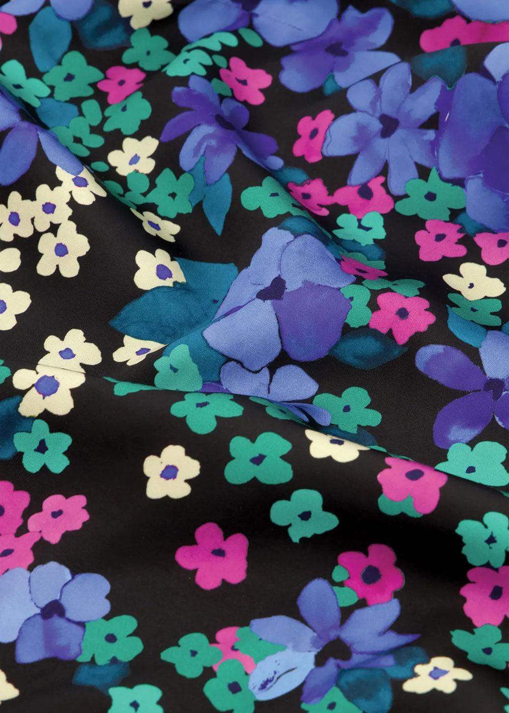 Vibrant floral print fabric with blue, purple, green, and pink flowers on a black background