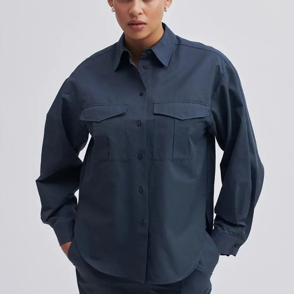 Model wearing a dark navy utility shirt with front pockets and matching trousers
