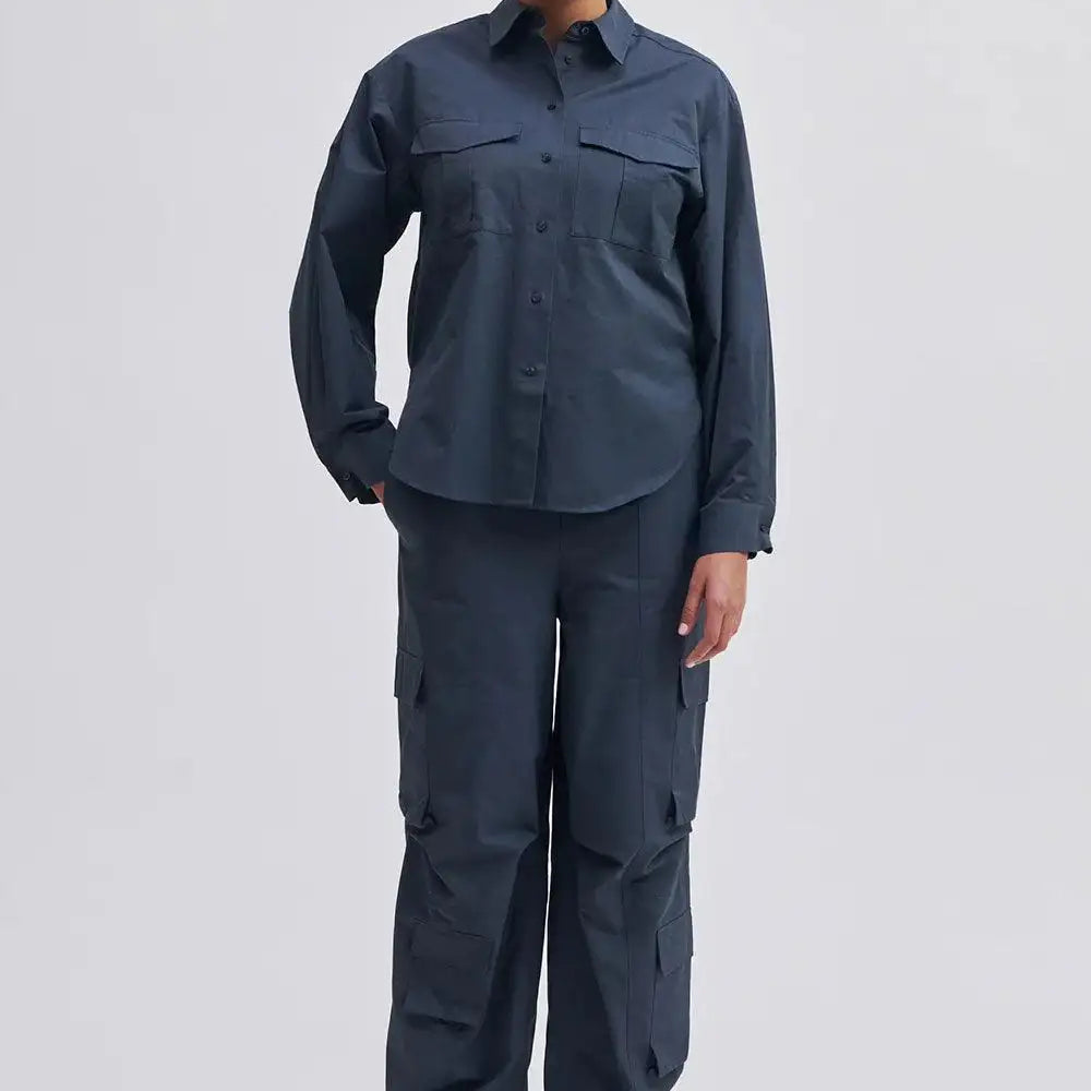Woman modeling navy utility shirt and cargo trousers with patch pockets and black chunky boots