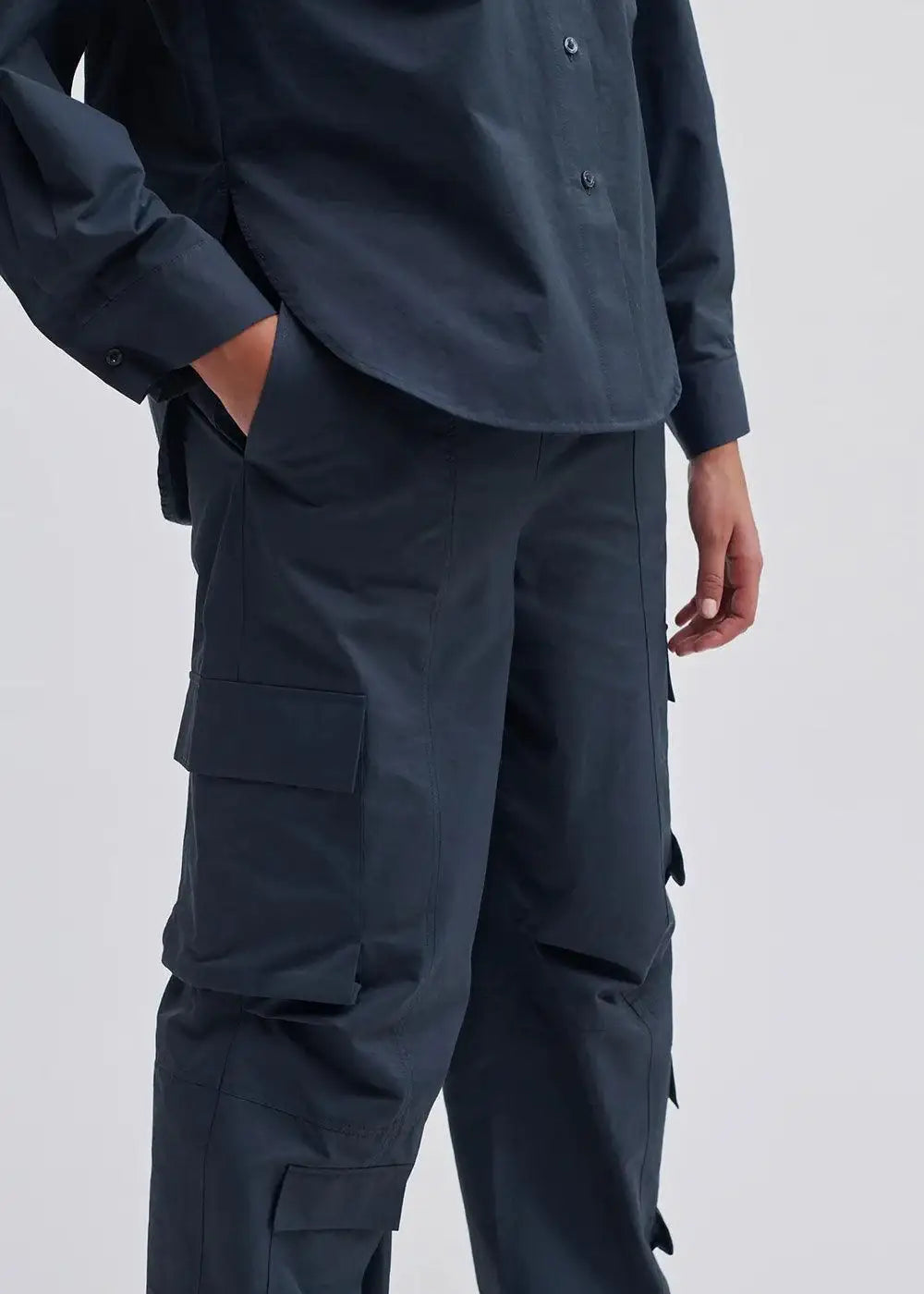 Woman wearing navy cargo trousers with pockets and matching button-up shirt