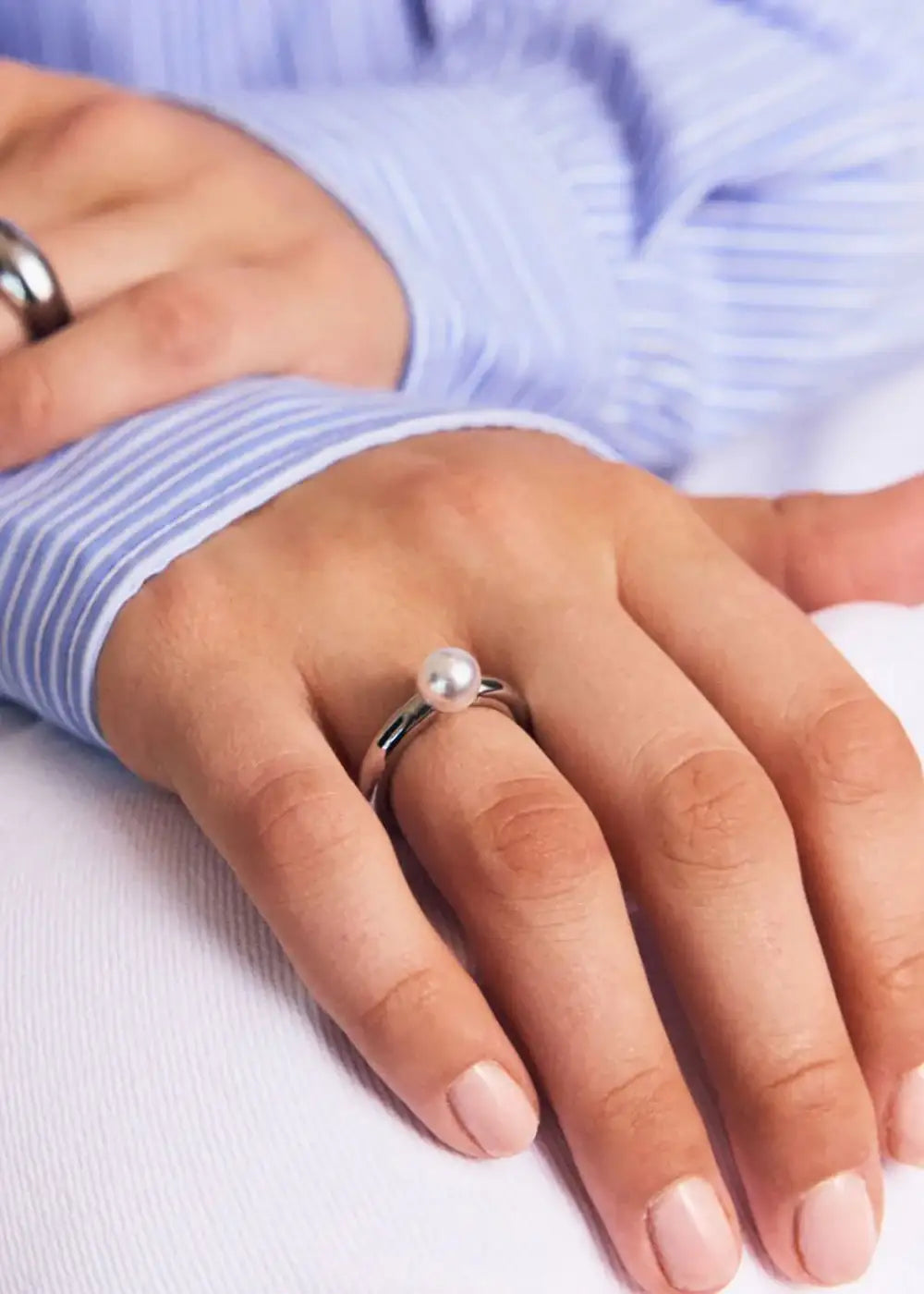 Modern silver ring with a single pearl detail on hand, minimalist jewelry style