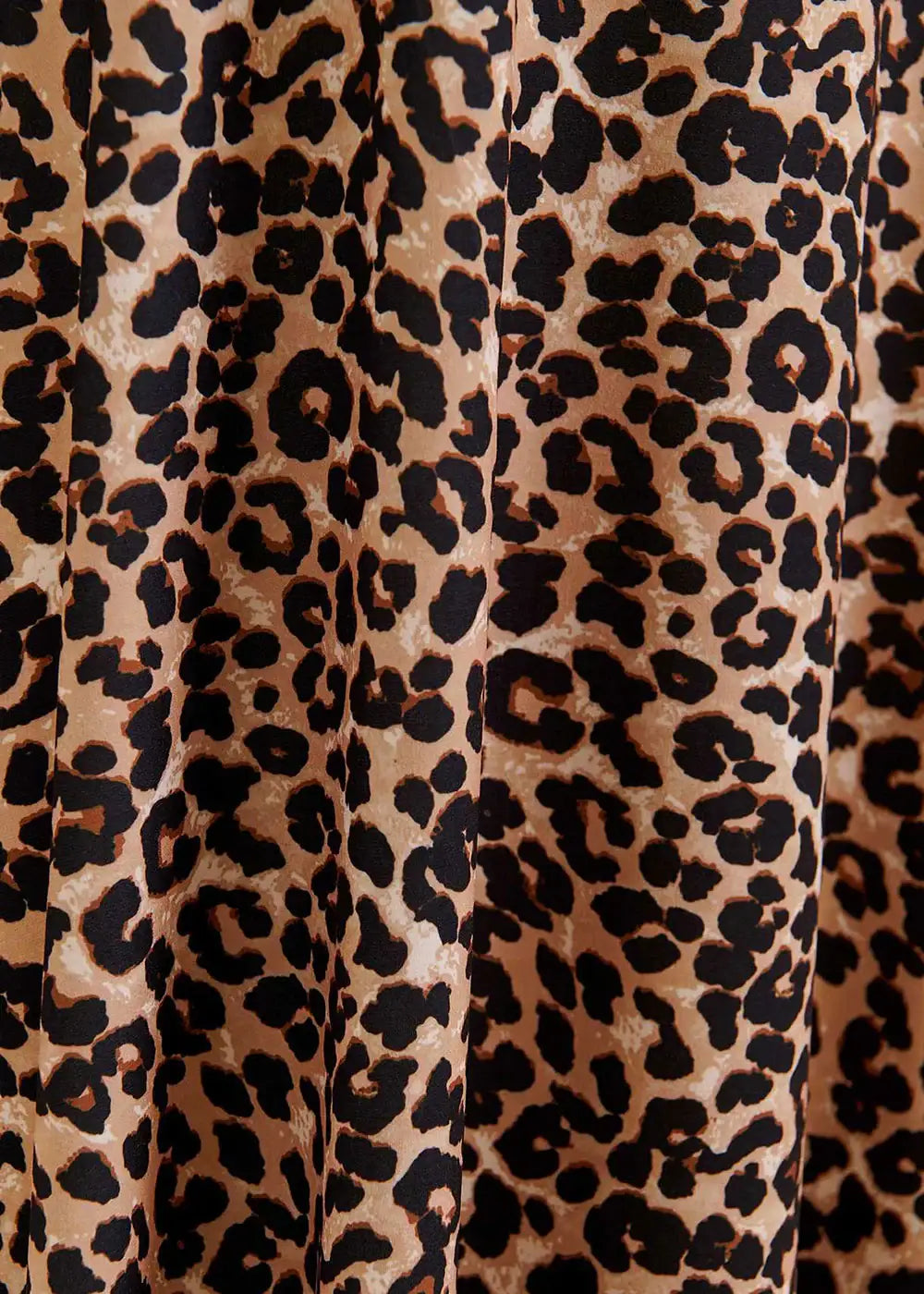 Brown and black animal print fabric close-up, leopard pattern texture