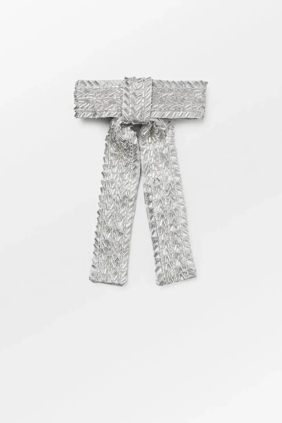 Silver sequin embellished bow brooch with beaded detail on white background