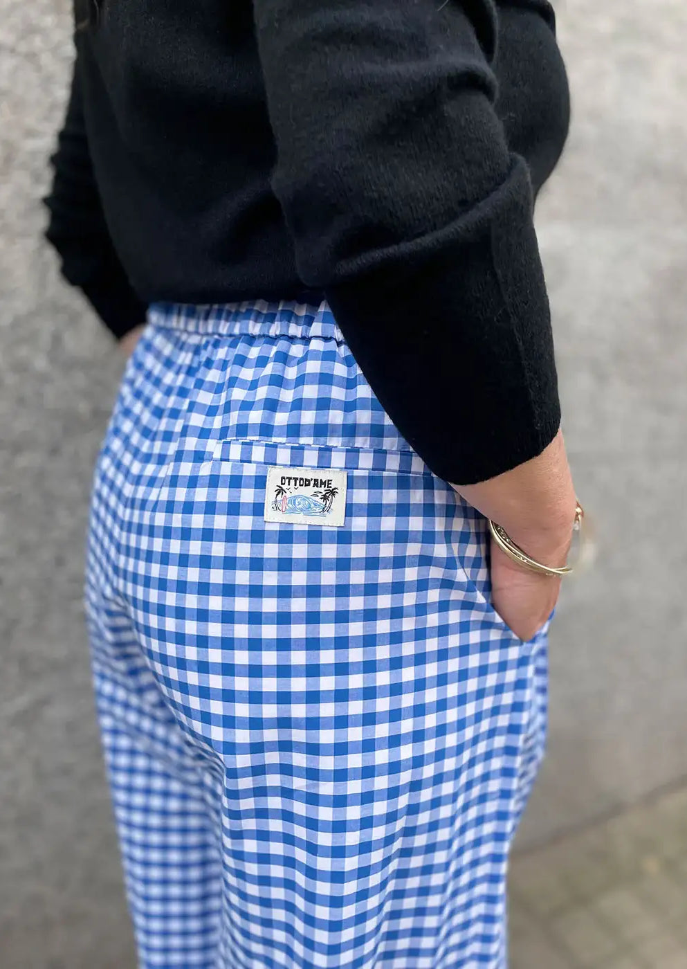 Blue and white gingham check trousers with patch pocket, worn with black sweater