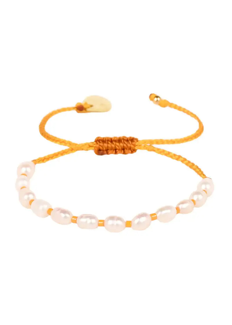 Yellow adjustable bracelet with white freshwater pearls on a white background