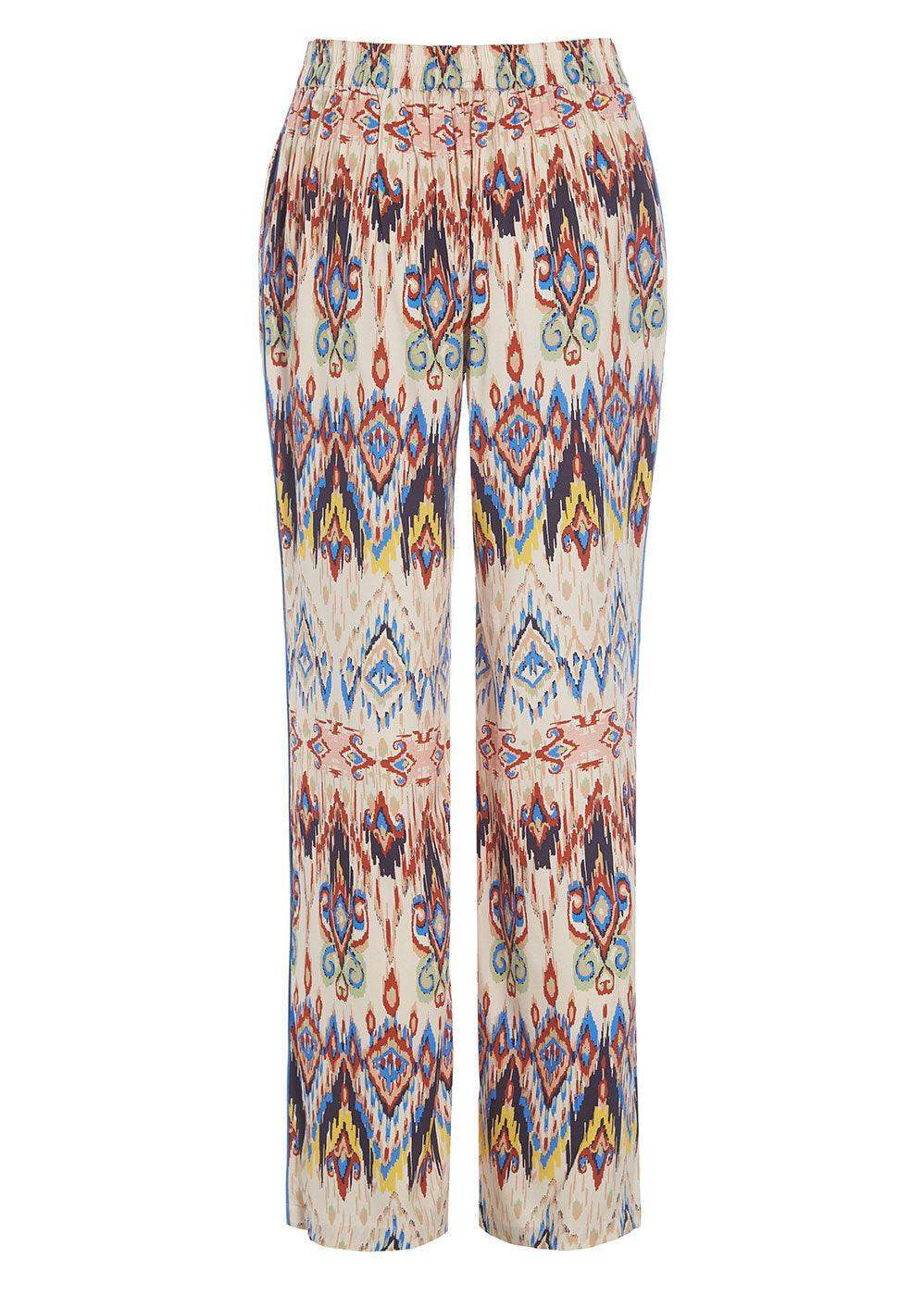 Cream wide-leg trousers with vibrant geometric ikat print in blue, red, yellow, and black