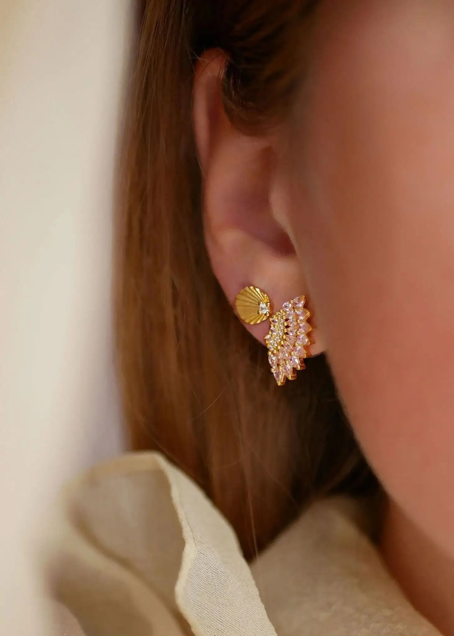 Gold and light pink enamel statement earrings with cubic zirconia on ear