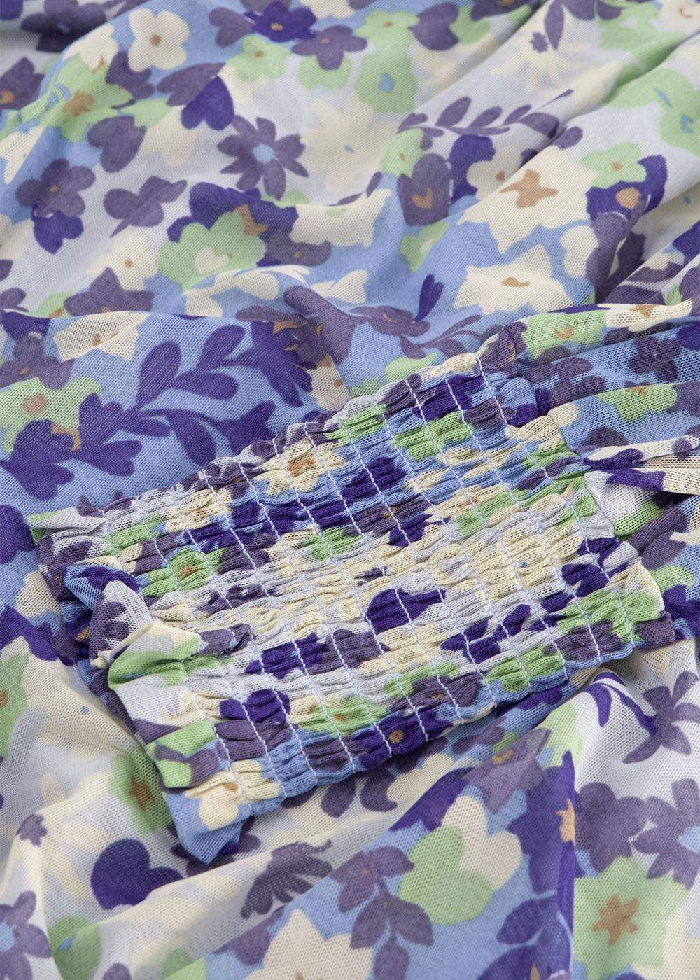 Close-up of pastel blue, green, and purple floral print fabric with ruched detail