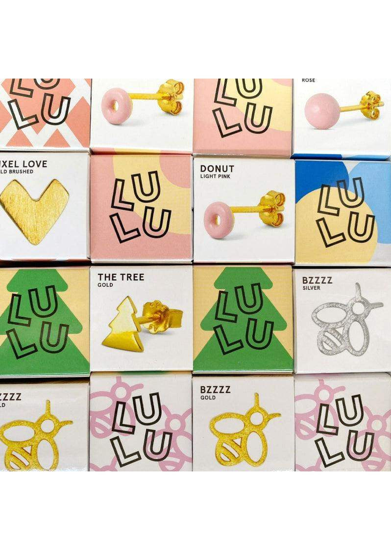 Light pink enamel donut stud earring with gold post, displayed in a grid of colorful earring boxes.