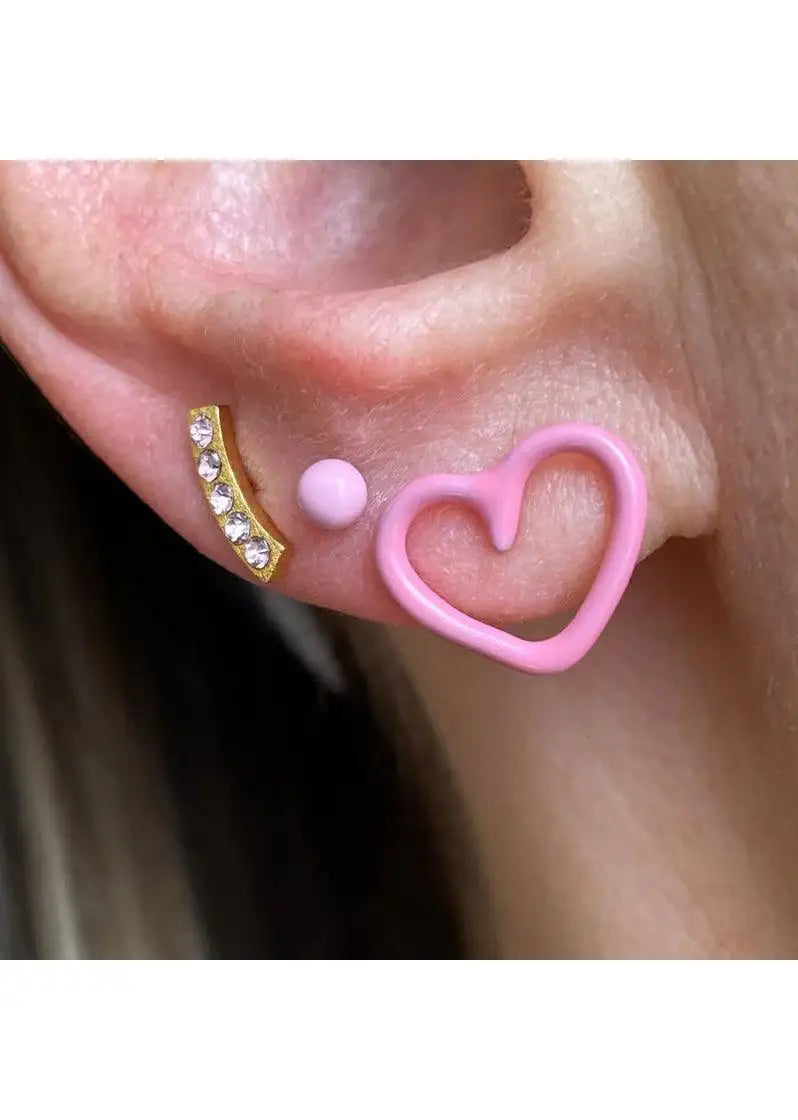 Pink heart-shaped earring with gold and crystal accent earrings on ear, close up jewelry photo
