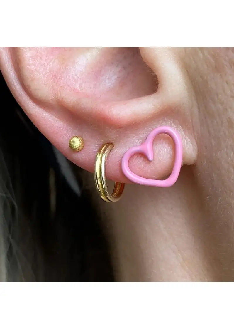 Close-up ear with pink heart hoop earring, gold hoop, and gold stud, minimalist jewelry