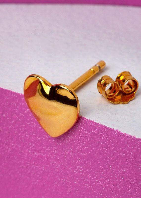Gold melted heart stud earring with butterfly back on pink and white textured background