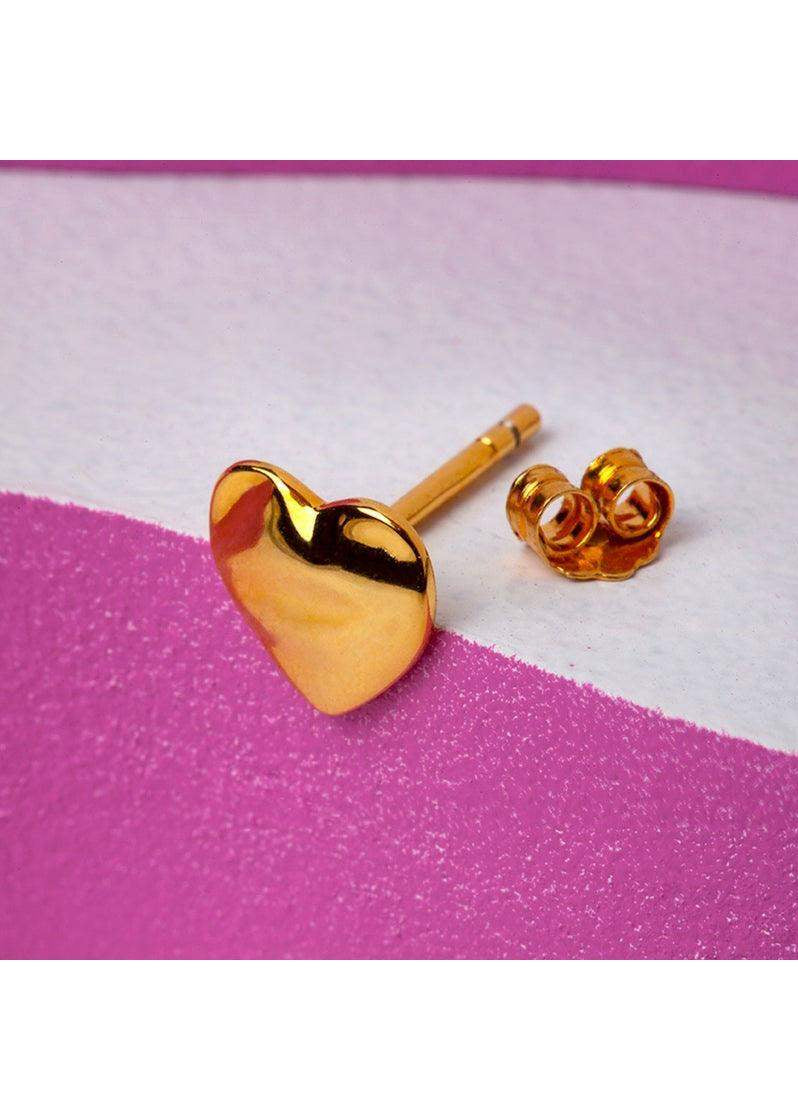 Gold melted heart stud earring with butterfly back on a pink and white background