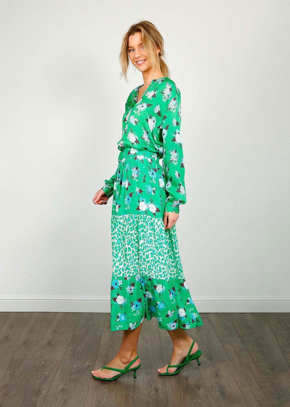 Woman wearing a green floral and animal print midi skirt and top set with strappy heels