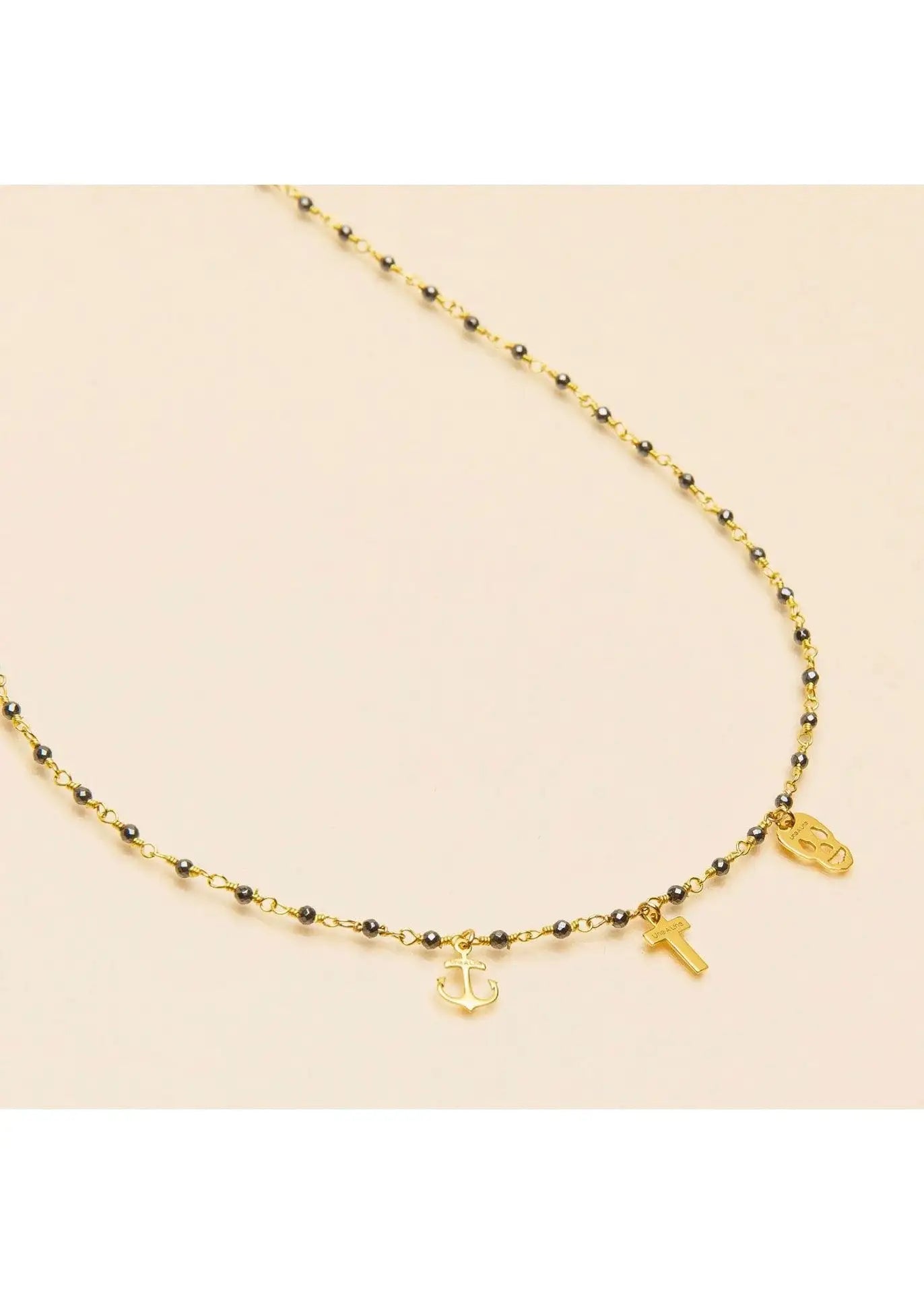 Gold pyrite necklace with anchor, cross, and skull charms on a beaded chain