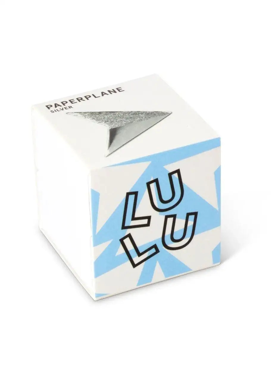 Small white and blue box with silver paper plane design and bold text on the side