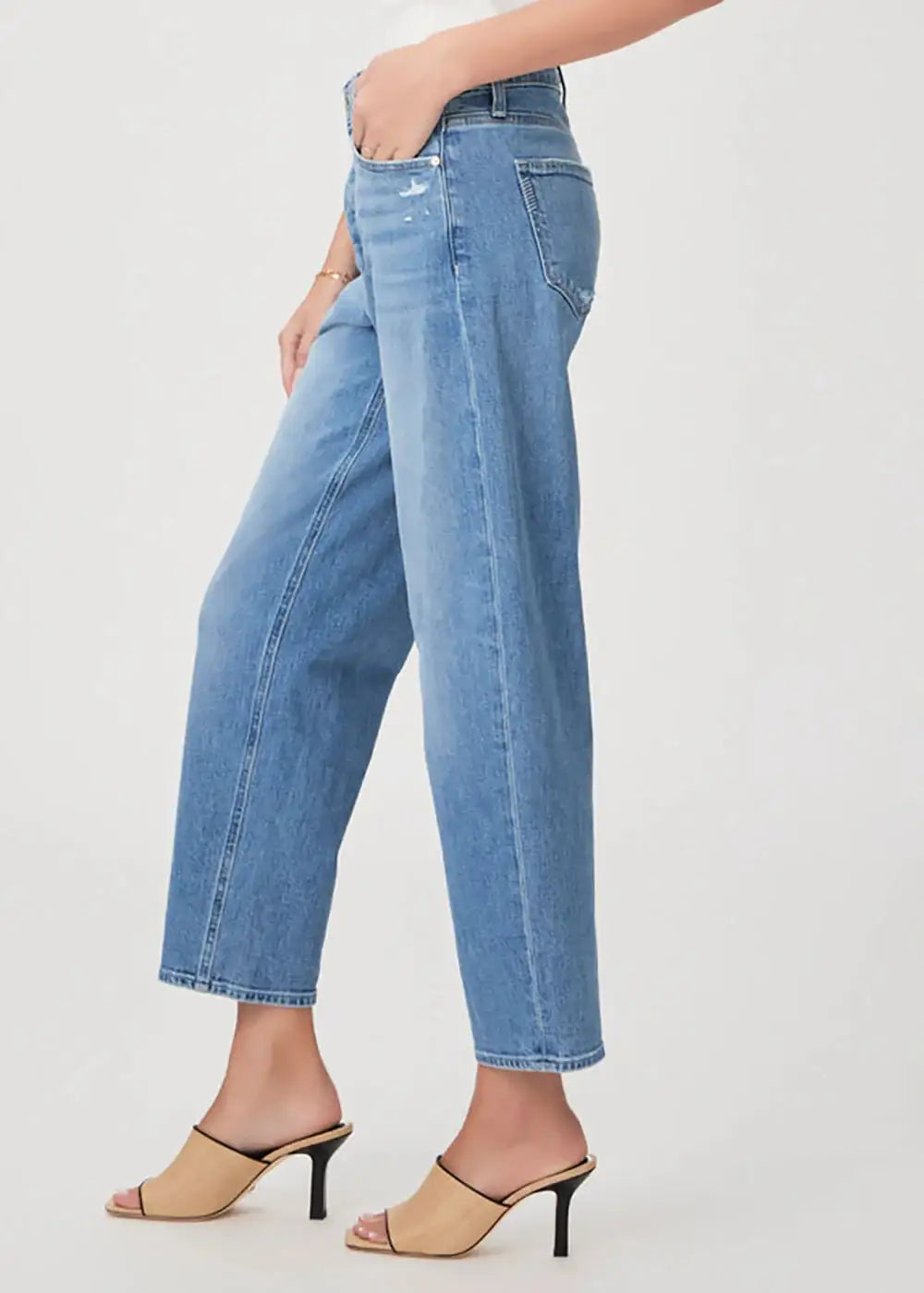 Woman wearing light wash straight leg jeans and beige heeled sandals