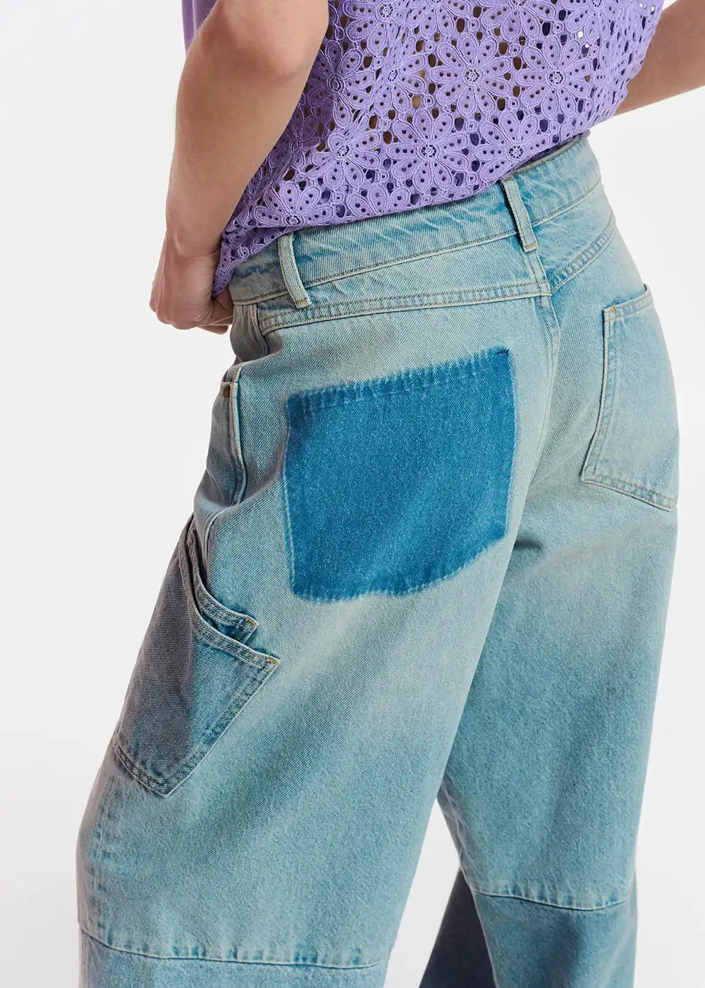 Light blue wide leg jeans with contrasting darker blue patch pocket, worn with lilac lace top