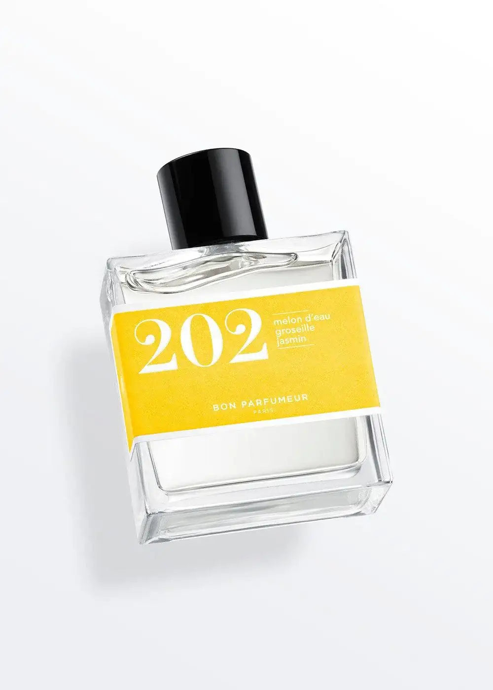 Clear glass perfume bottle with a black cap and a yellow label reading '202'.