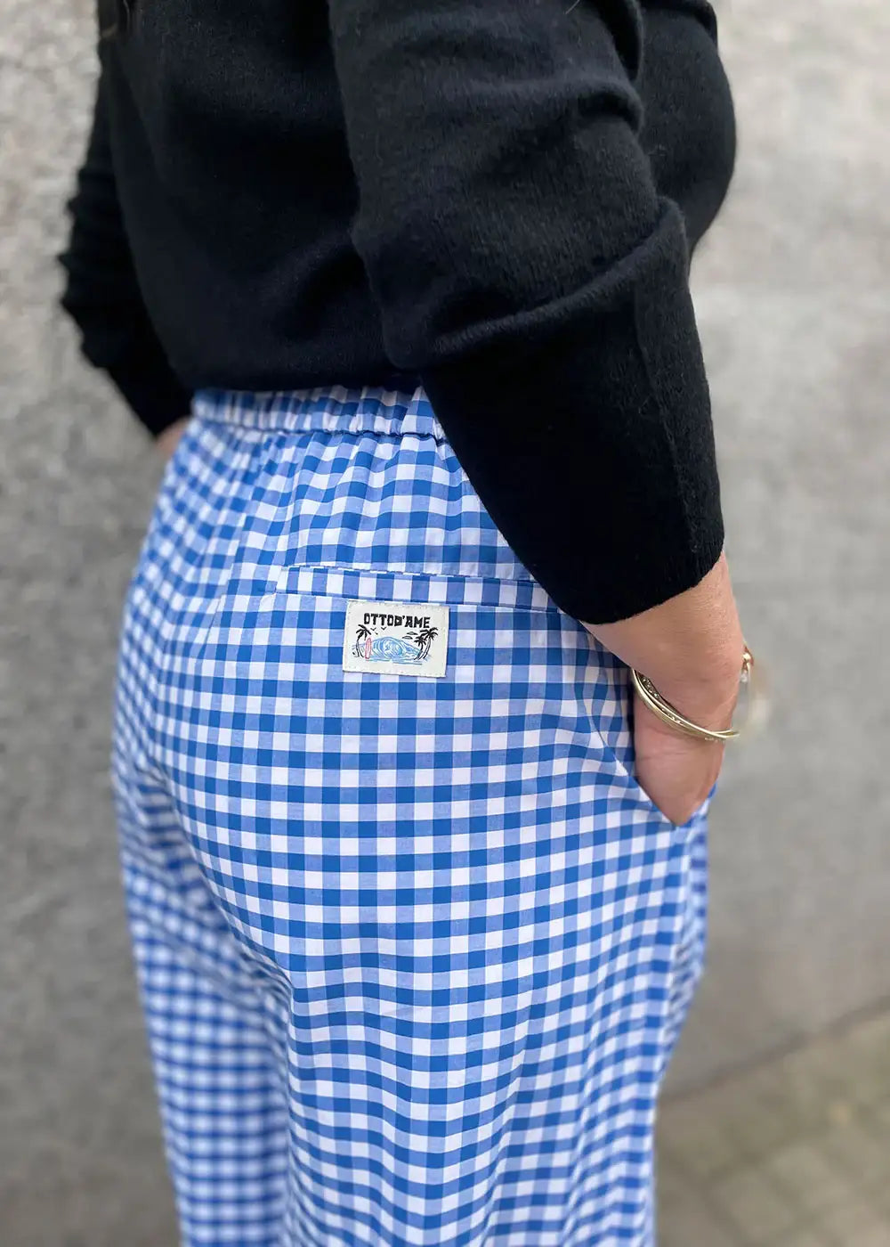 Blue and white gingham check trousers with patch pocket, worn with black sweater